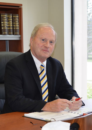 Brian Forbes, the Chairman of NCVA, sitting at his desk in the office.