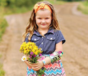 Jaelynn, a left arm amputee, holding a bouquet of beautiful wildflowers using her myoelectric arm.