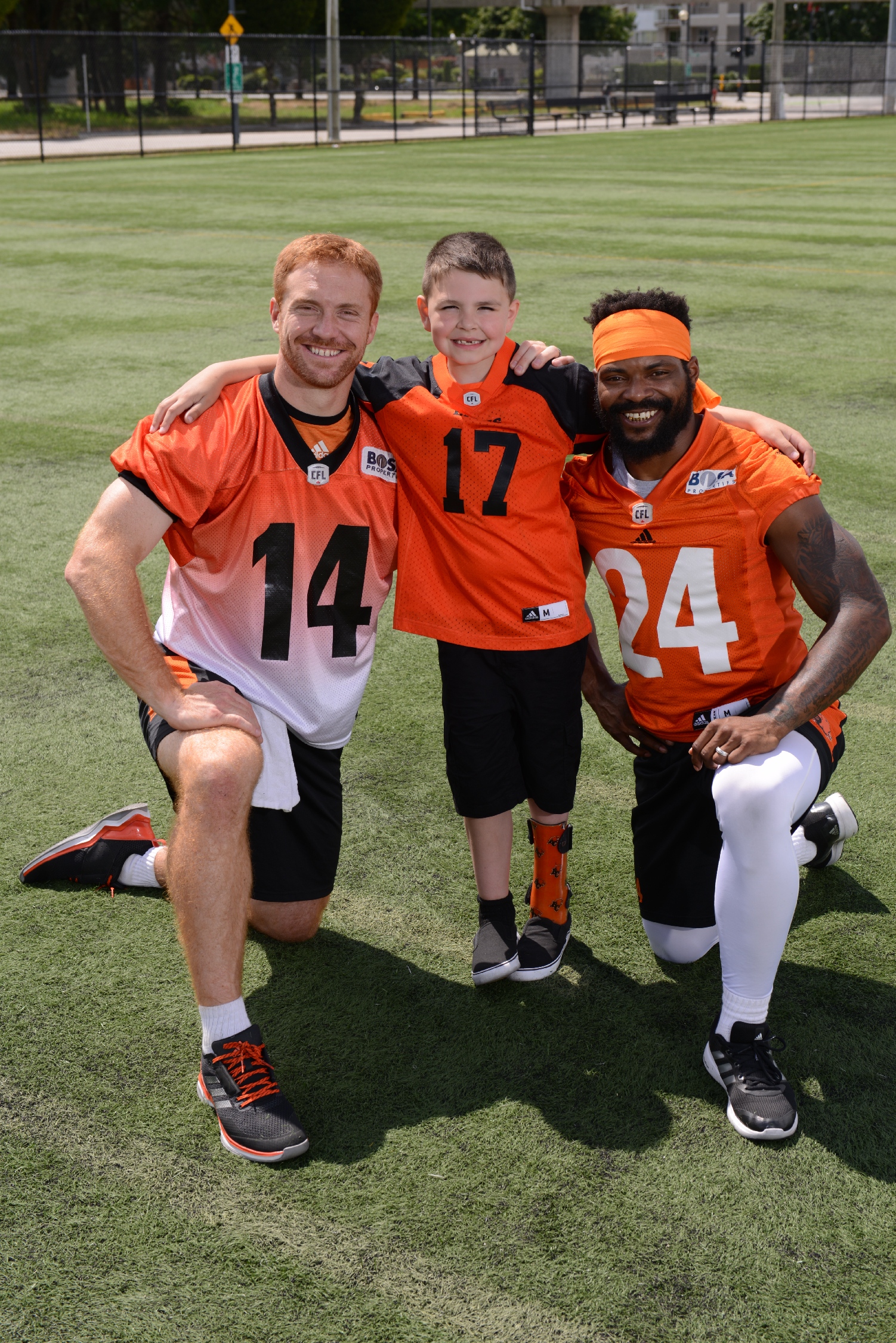 Darevin teams up with BC Lions players Travis Lulay (#14) and Jeremiah Johnson (#24).